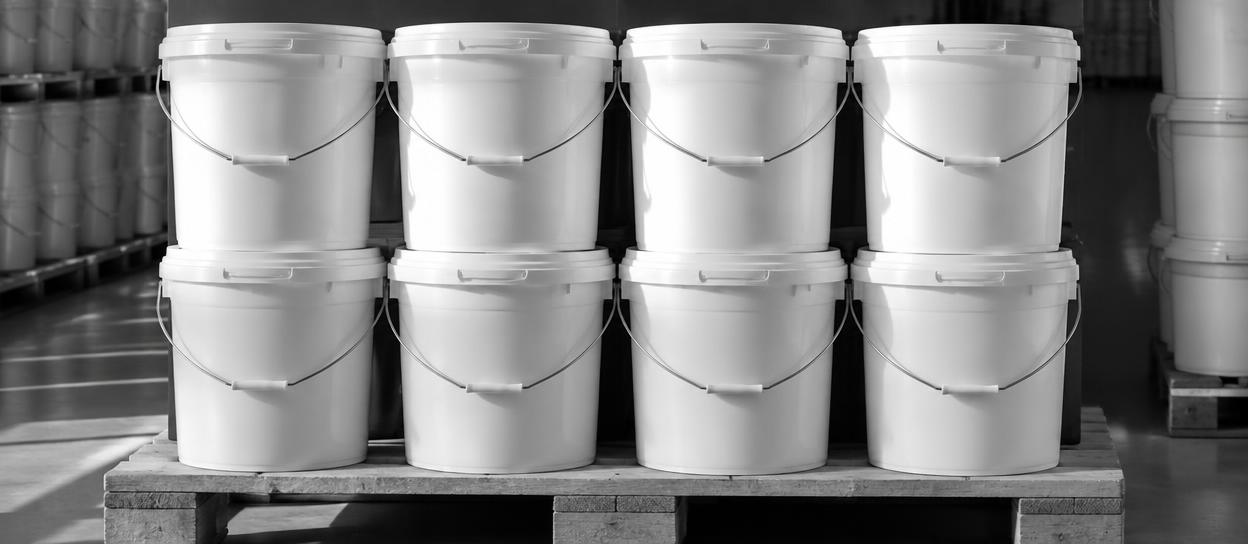 Plastic pails stacked neatly on a warehouse pallet